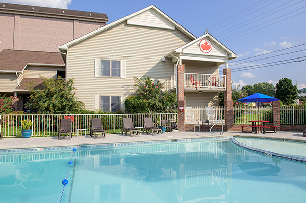 A hotel building with a pool area in front of it.